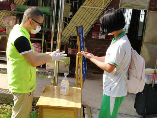 已處理15880385979016、志愿者正為體溫正常進(jìn)入校園的學(xué)生進(jìn)行手部消毒.png